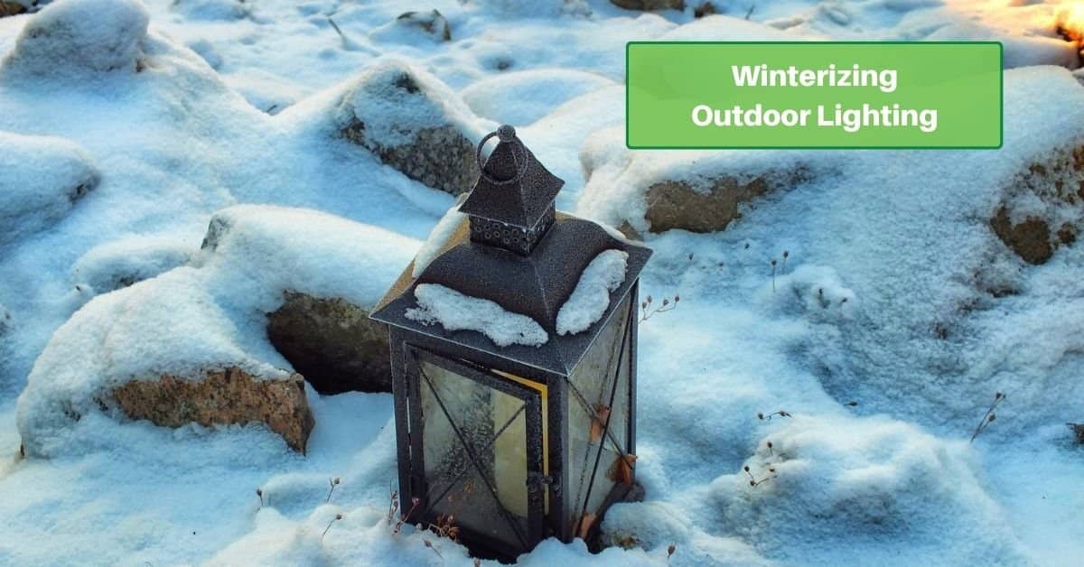 a 4-sided lantern sitting in the snow. text reads, winterizing outdoor lighting